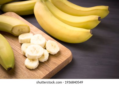 A bunch of bananas and a sliced banana   on a table, delicious, natural.