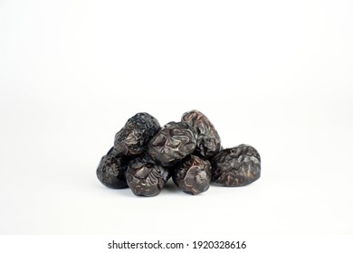 Bunch Of Black Dates Close Up On A White Background.