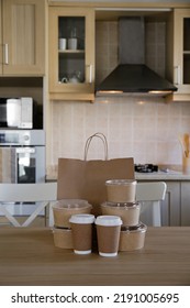 Bunch Of Blank Disposable Containers For Takeout Food Stacked With Paper Bags, Cups And Boxes With Copy Space For Brand's Logo. Close Up Shot Of Eco Friendly To Go Carton Bowls On Table.