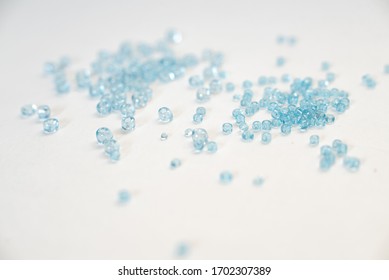 A bunch of blue seed beads of different size on white - Powered by Shutterstock