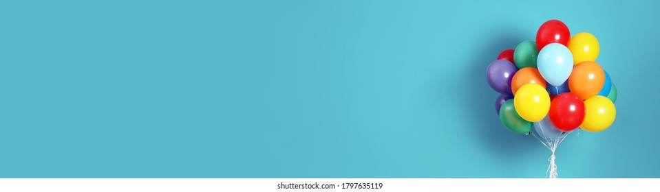 Bunch of bright balloons on light blue background, space for text. Banner design 