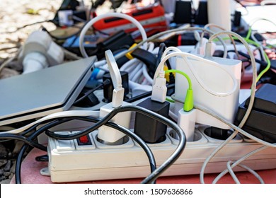 a bunch of charging gadgets, electronic devices, messy wires. dependence on electricity - Powered by Shutterstock