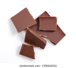 Bunch Of Chocolate Pieces On White Background. Top View. Isolated