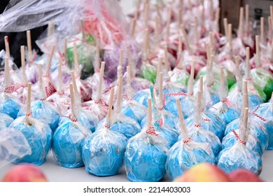 A Bunch Of Colorful Candy Apples On A Table During A Small Town Festival