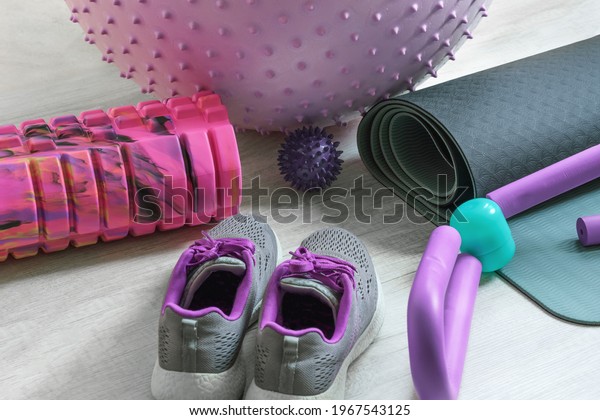 Bunch of colorful\
fitness accessories, equipment for physical workout at home.\
Exercise mat, sneakers, massage roller and ball, fitball. Active\
healthy lifestyle\
concept.