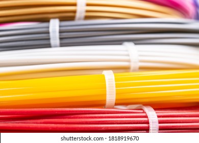 Bunch of colorful rolled cables. Closeup of plastic bright wires for 3D printer lying indoors, white studio background. Concept of children's entertainment and creativity. - Shutterstock ID 1818919670