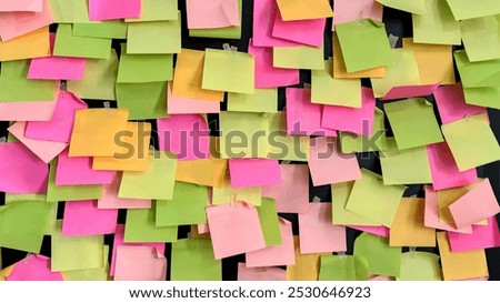 A bunch of colorful sticky notes on the blackboard as a messaging tool to encourage people. Concept of promoting creativity and collaboration.