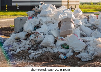A bunch of construction debris in white bags near a new building, garbage in bags - Shutterstock ID 2078510965
