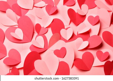 Bunch of cut out of pink and red paper hearts on pink background. Cute Valentines day, Womans day, love, romantic or wedding card, banner, invitation, sale, offer, ad background