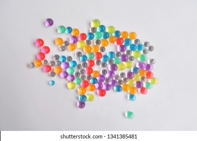 Bunch of cute glass bead in a blank background upper view Water coloured gel balls. Polymer gel. Silica gel. Balls of hydrogel. Texture background. Close up macro