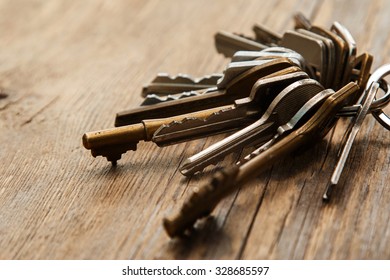 Bunch of different keys on wooden surface