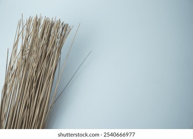 Bunch of dried grass sticks arranged on a white background, showcasing natural texture and rustic decor - Powered by Shutterstock