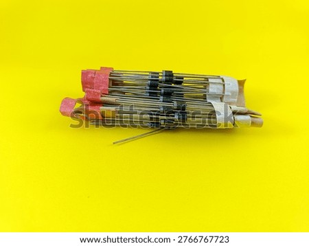 A bunch of electronic diode components on a yellow background. Semiconductor rectifier diodes for circuit board assembly and electronic power supply repair.