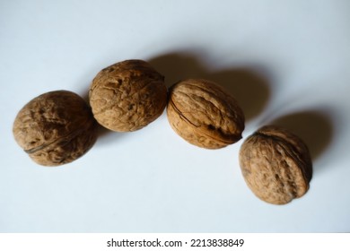 Bunch Of Four Ripe Brown Rounded Wrinkly Fruits Of Persian Walnut