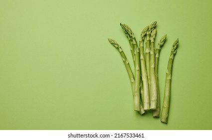 Green asparagus bunch on wicker tray on white table background