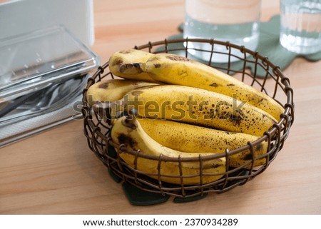 A bunch of fresh banana lie on the dining table in a modern kitchen, healthy life concept.