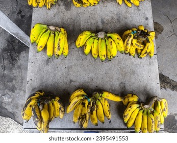 a bunch of fresh bananas on display and for sale in a traditional fruit shop - Shutterstock ID 2395491553