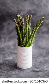 A bunch of fresh green asparagus in a can