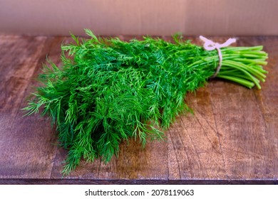 Bunch of fresh green dill isolated on wooden background