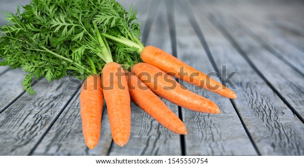 Bunch of fresh juicy carrots on wooden background
