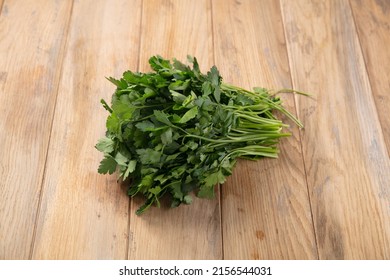 A bunch of fresh parsey on the table. Fresh herbs for salad. Catalog, on wooden bachground, ingredient. .tif