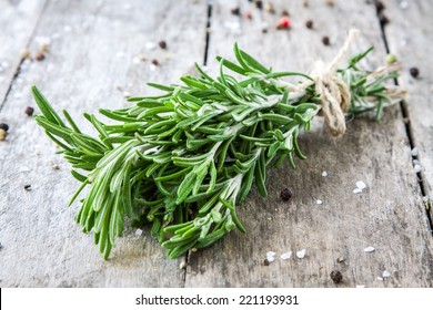 a bunch of fresh rosemary on a wooden background