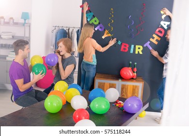 Bunch Of Friends Preparing Decorations For Surprise Birthday Party