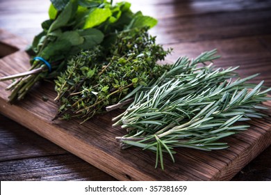bunch of garden fresh herbs on wooden board from above - Shutterstock ID 357381659
