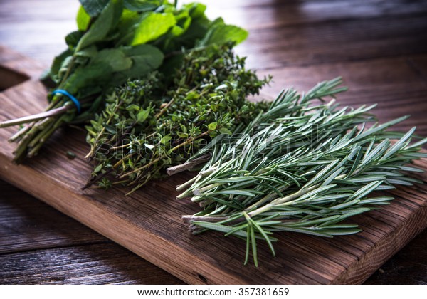 bunch of\
garden fresh herbs on wooden board from\
above