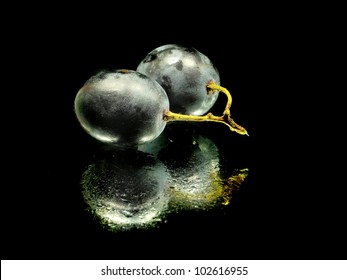 bunch of grapes on a black background with water drops