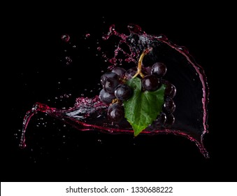 Bunch of grapes with red juice splash isolated on black background