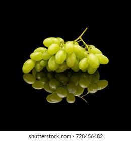 Bunch of green grapes with water drop. On a black glossy background with real reflection.