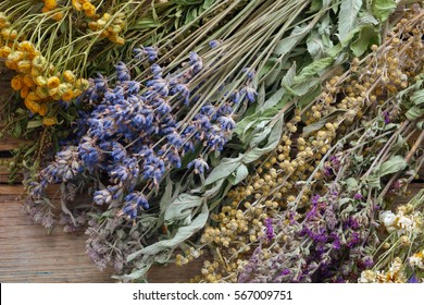 Bunch of healing herbs on wooden board. Herbal medicine. Top view, flat lay.