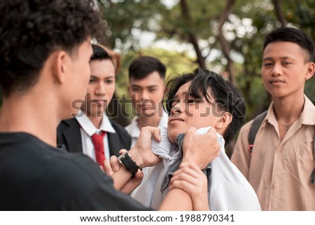 A bunch of high school delinquents bully a smaller boy. One bully grabs him by the collar. Emotional and physical abuse issues in teenagers.