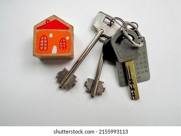 a bunch of house keys and a cube with the image of a house on a light background