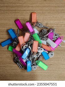 Bunch of key with multi colour tag, keys kept on table top, top view of keys with different colours key chain attached to the key. 