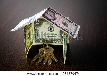 bunch of keys inside a house made from dollar banknotes