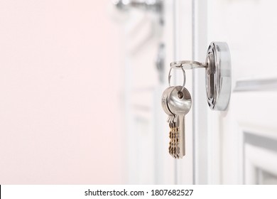 A Bunch Of Keys In The Keyhole. White Door. The Concept Of Financial Lending Or Mortgages.Housewarming In A New Home.Copy Space.