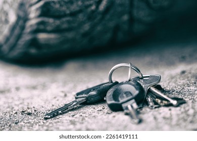 a bunch of keys lies under the wheel of the car. Loss of keys. High quality photo - Shutterstock ID 2261419111