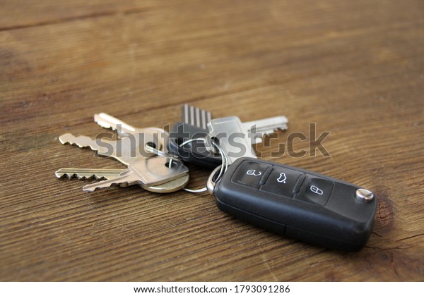 bunch of keys from the locks and the car lies on an\
old wooden table, natural textures, concept of discovery, secrets,\
clues, buying real estate, houses, apartments, mortgages, housing\
loans, cars