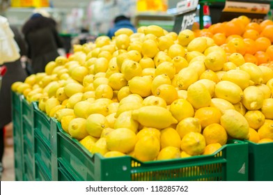 Bunch of lemons and oranges on boxes in supermarket