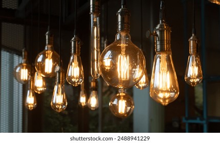 A bunch of light bulbs hanging from the ceiling. The bulbs are all different shapes and sizes, but they all have a warm, yellow glow. The scene gives off a cozy, inviting atmosphere - Powered by Shutterstock