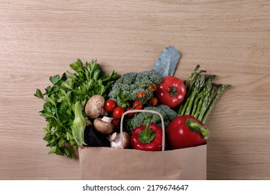 Bunch Of Mixed Vegetables, Herbs And Greens In A Brown Paper Bag. Vegan Diet Products. Clean Eating Concept. Eco Friendly Bag Full Of Groceries. Close Up, Copy Space, Background, Top View, Overhead