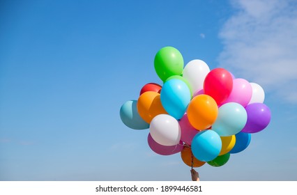A bunch of multicolored balloons with helium on a blue sky background