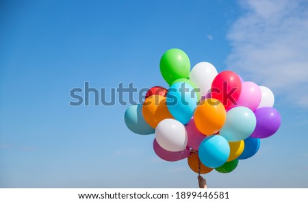 A bunch of multicolored balloons with helium on a blue sky background