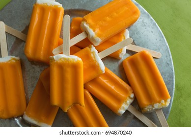 A bunch of orange creamsicle treats on a galvanized tray. 