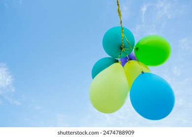 Bunch of pastel color balloons floating in the air against blue sky - Powered by Shutterstock