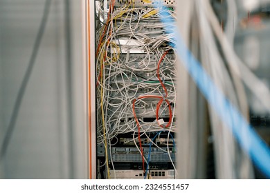 a bunch of patch network cables sorted in a rack cabinet leading from a patch panel in a server rack in data center room internet cloud storage