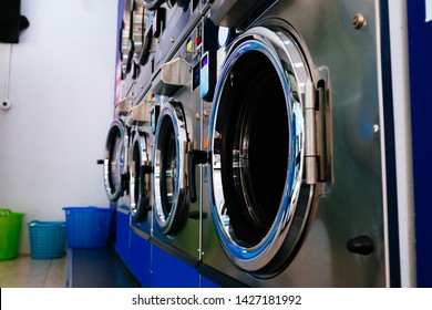 Bunch of professional industrial washing and drying machines in laundry service store - clothing cleaning business concept