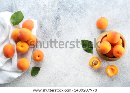 Bunch of ripe organic apricots in pile on grunged concrete textured table. Local produce harvest heap. Clean eating concept. Background, top view, close up, copy space, flat lay.